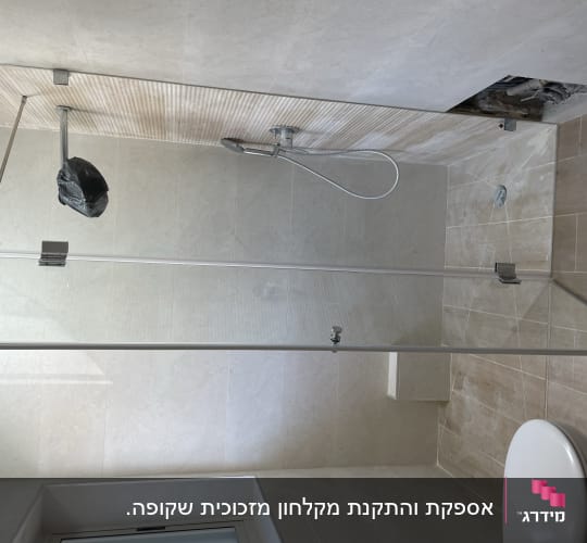 מקלחת עם דלת זכוכית וברז מקלחת כסוף